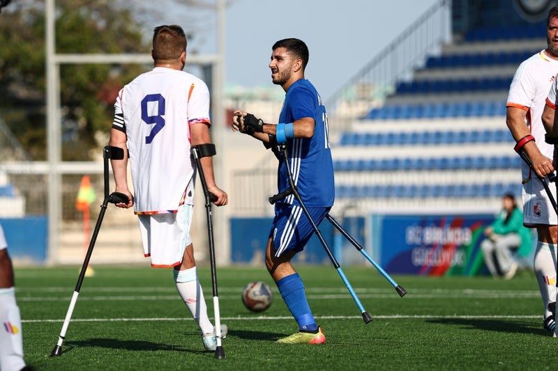 Two players on crutches battle for the ball along the touchline