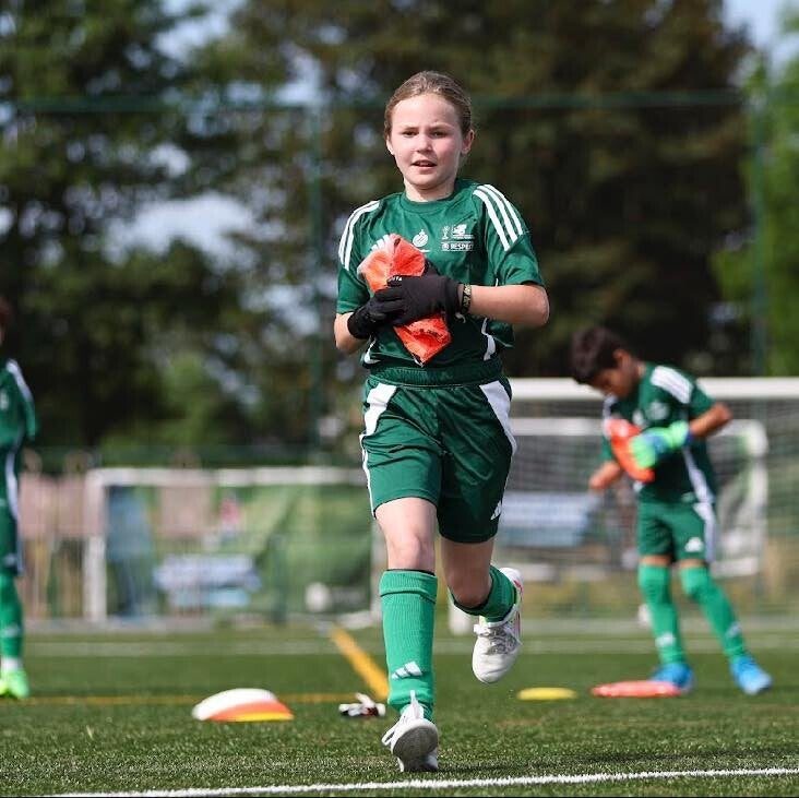 A girl runs with the ball at the junior camp